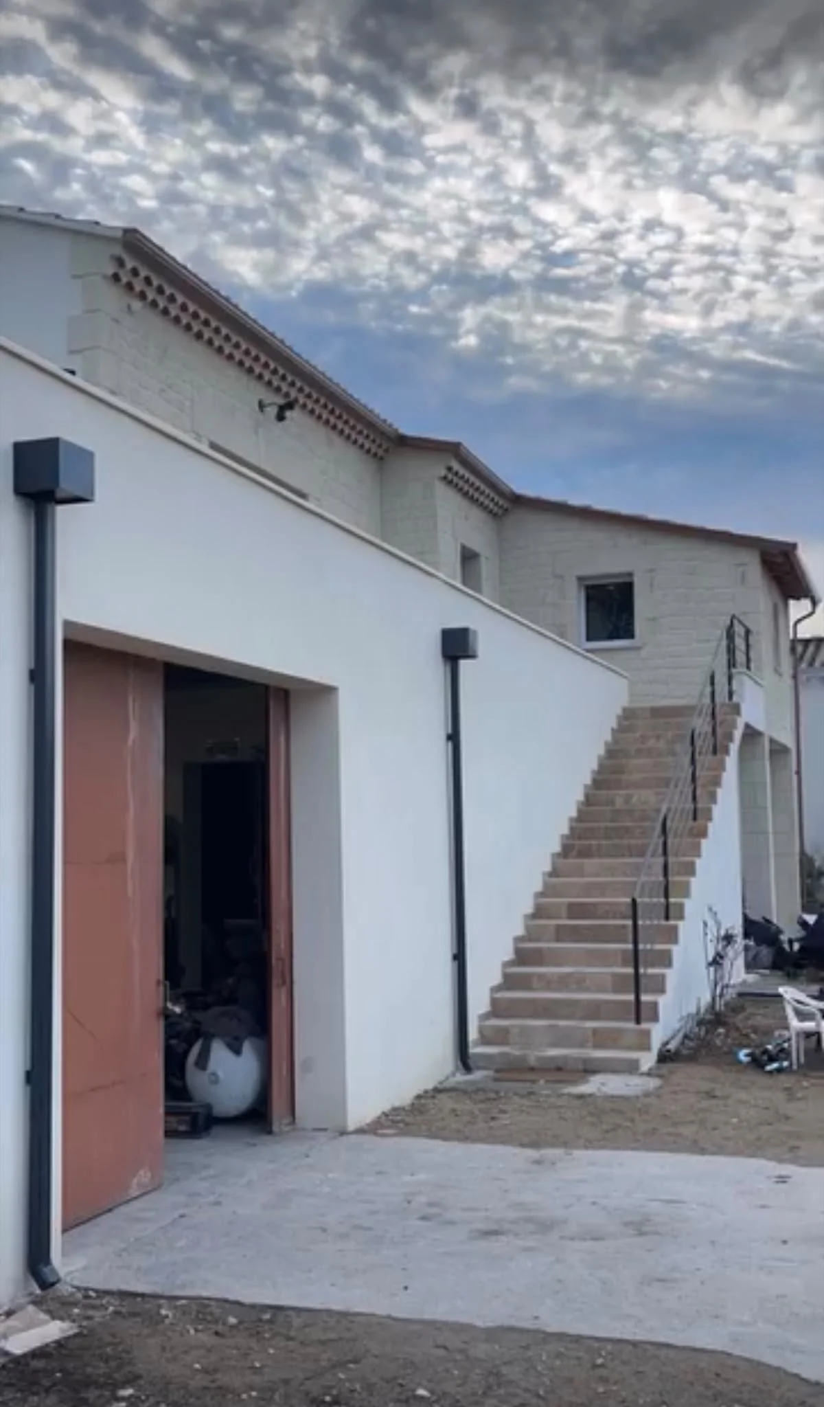 Descente pluviale anthracite le long d'une façade avec escalier extérieur