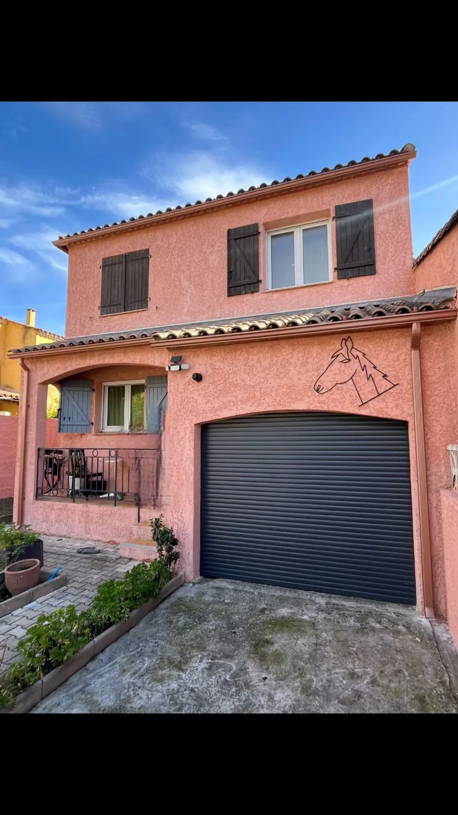 Débord de toiture habillé et gouttière foncée sur une maison de ville