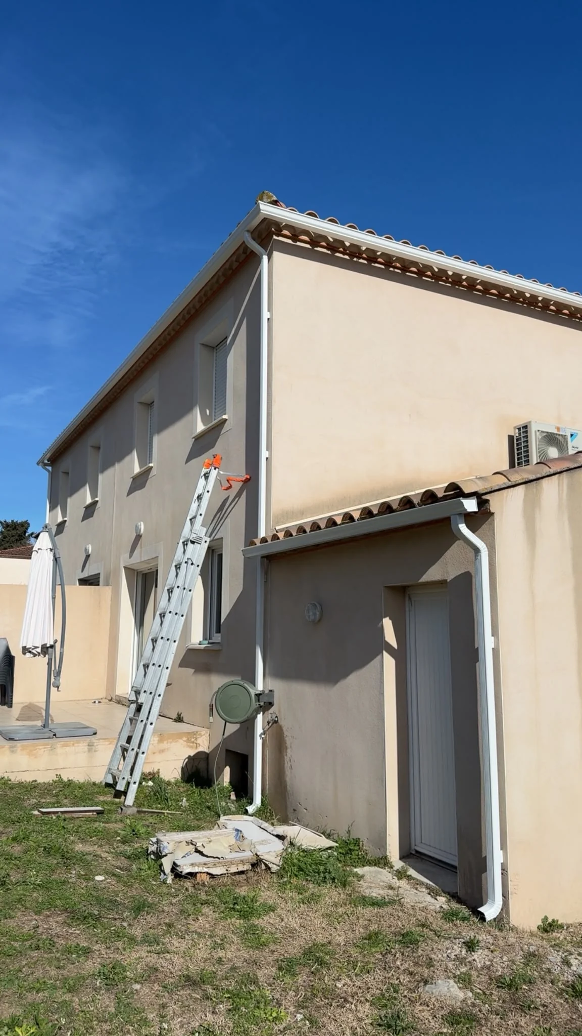 Descente aluminium blanche installée en angle de façade