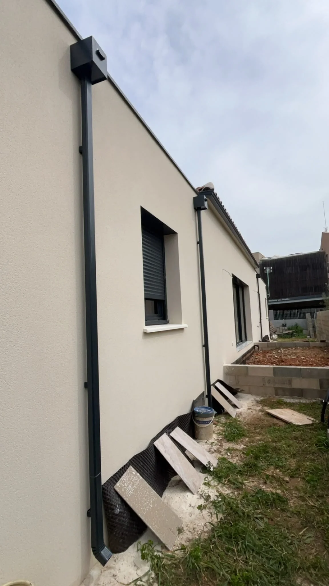 Boîte à eau anthracite avec descente rectangulaire sur façade